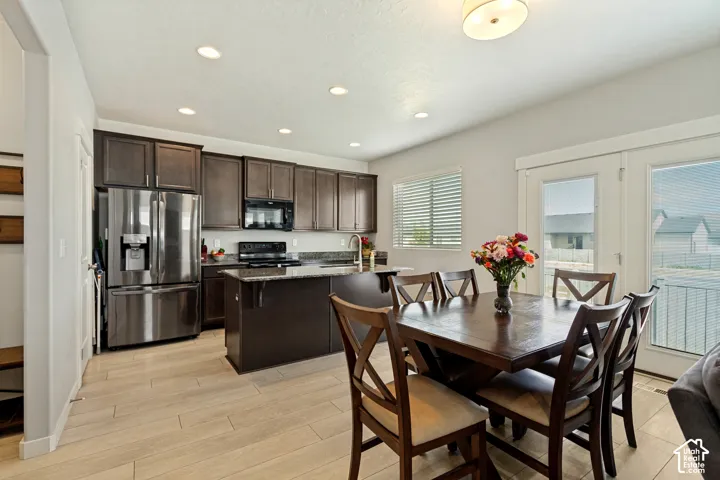 Kitchen featuring dark wood-finish cabinetry, stainless steel appliances, and a central island with a granite countertop