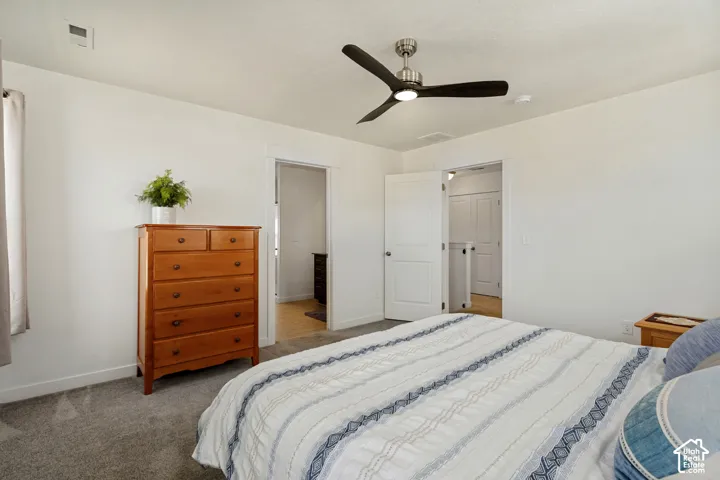 White walls, gray carpet flooring, and a contemporary ceiling fan with integrated lighting