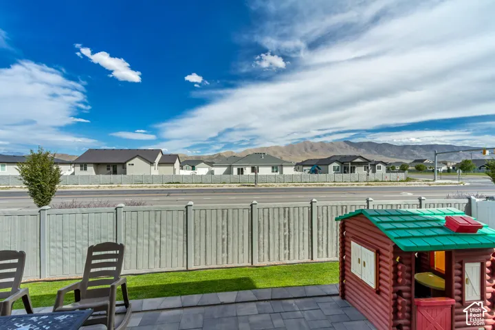 Patio area featuring paver flooring, a manicured lawn, and a light-colored privacy fence