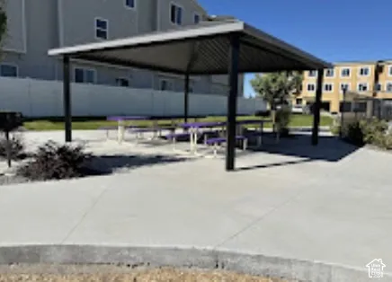 Covered outdoor seating area with concrete paving and integrated picnic tables
