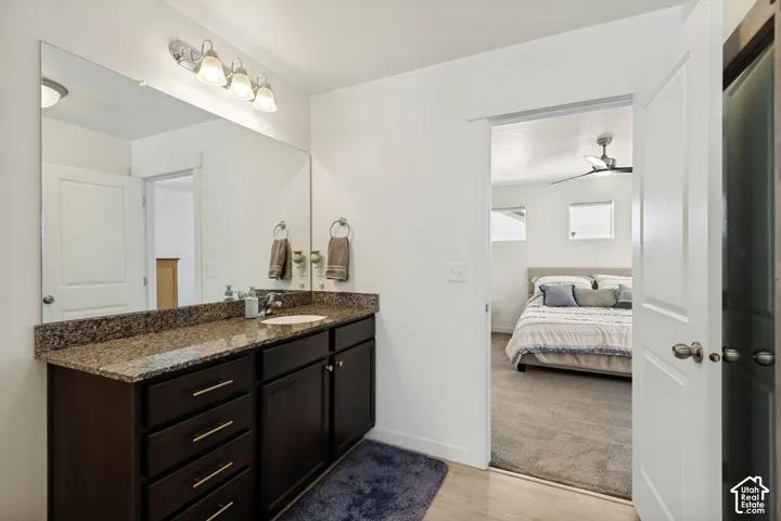Vanity with brown-toned cabinetry, a built-in sink, and a speckled countertop