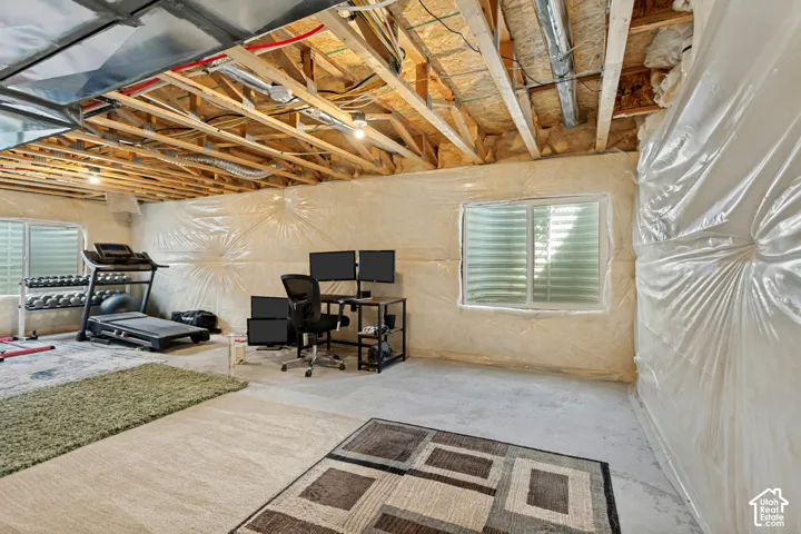 Unfinished basement with exposed ceiling joists and utilities