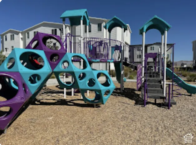 Playground area featuring multiple slides, climbing structures, and protective ground surfacing