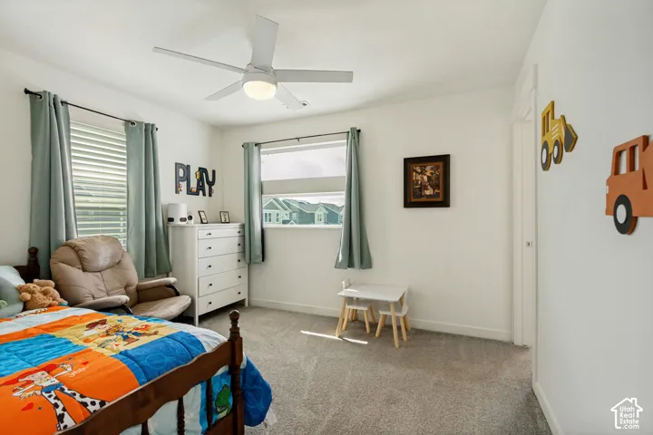 Recessed lighting, ceiling fan, two windows with blinds, and carpeted flooring