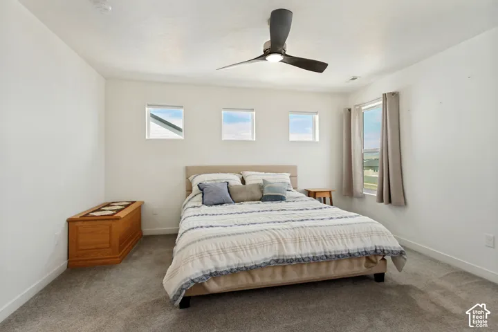Recessed lighting, ceiling fan, three square accent windows, and a large window with privacy coverings