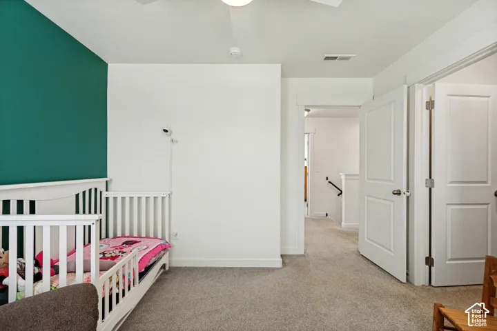 Plush carpeting throughout, white interior doors, and a modern ceiling fan