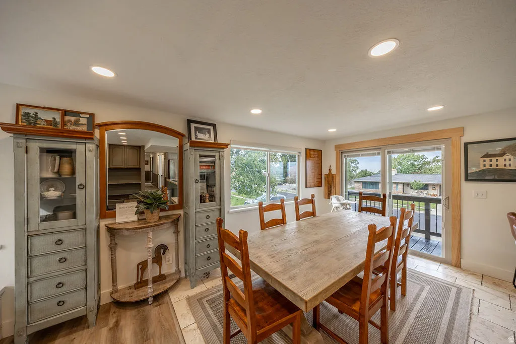 Recessed ceiling lighting, wood-finish flooring, tile flooring, sliding glass door with wood trim, and a built-in mirror with wood frame