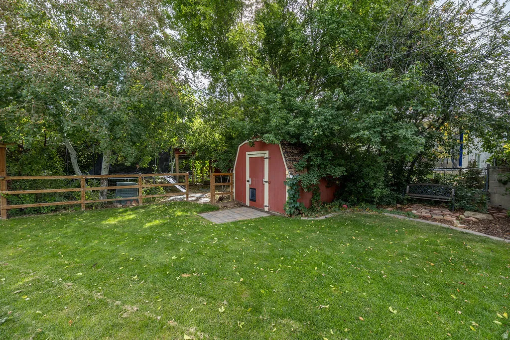 Expansive green lawn with mature trees and a wood-slat fence