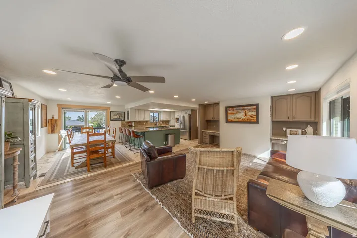 Open-concept living area featuring wood-finish flooring, recessed lighting, a ceiling fan, and built-in desk spaces