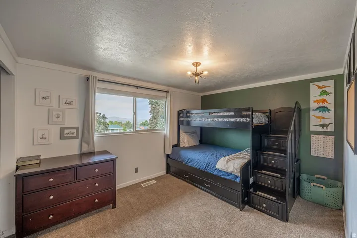 Carpeted flooring, window with exterior scenery, crown molding, and a modern ceiling light fixture