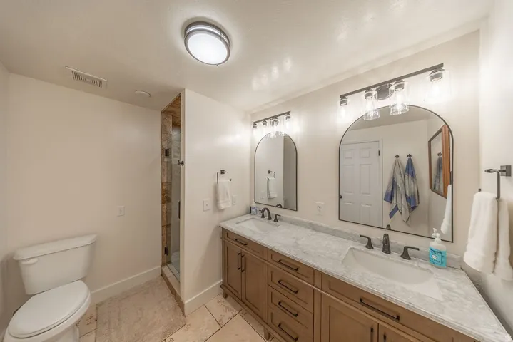 Dual vanity with undermount sinks and dark bronze fixtures set in a light-toned countertop