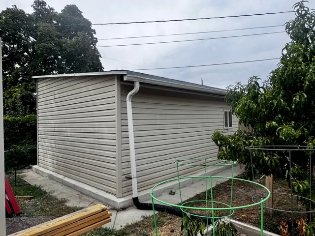 Siding exterior with a clean gutter system, a single window, and concrete foundation