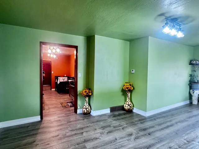 Wood-finish flooring throughout, with a contrasting wall color in the adjoining room