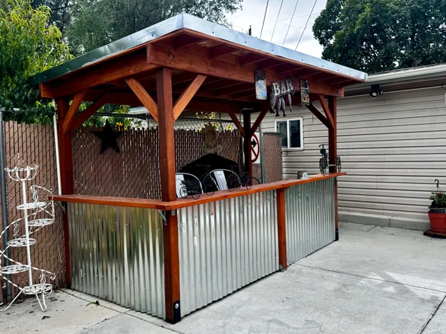 Outdoor BAR structure with a wood-finish frame, metal roof, and corrugated metal siding