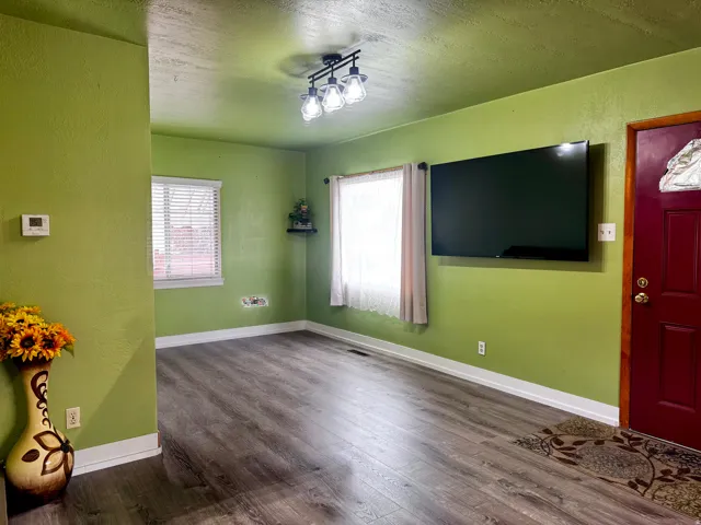 Wood-finish flooring throughout, track lighting fixture, and white window blinds