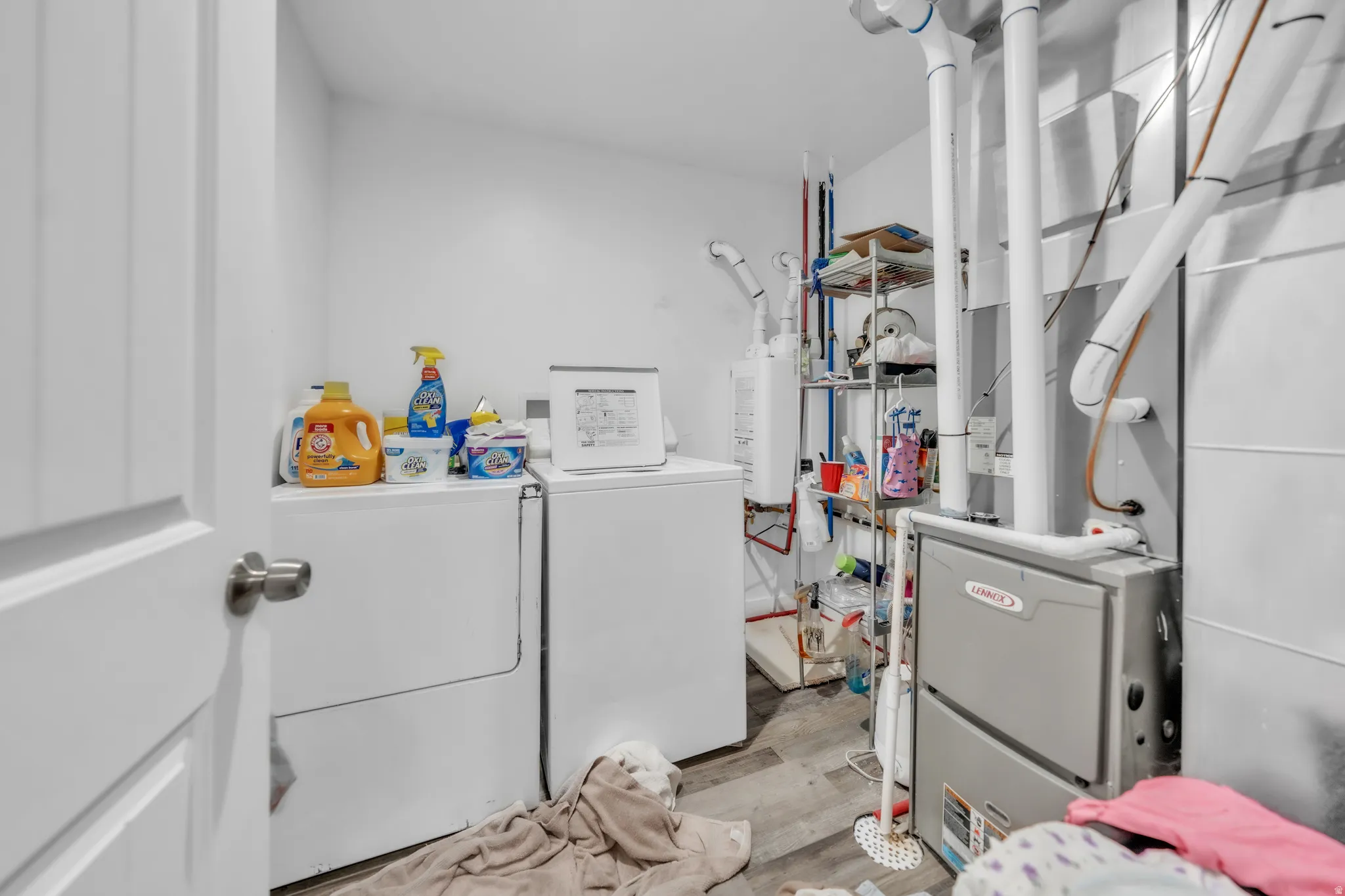 Dedicated utility space featuring wood-finish flooring, white walls, and a visible furnace unit