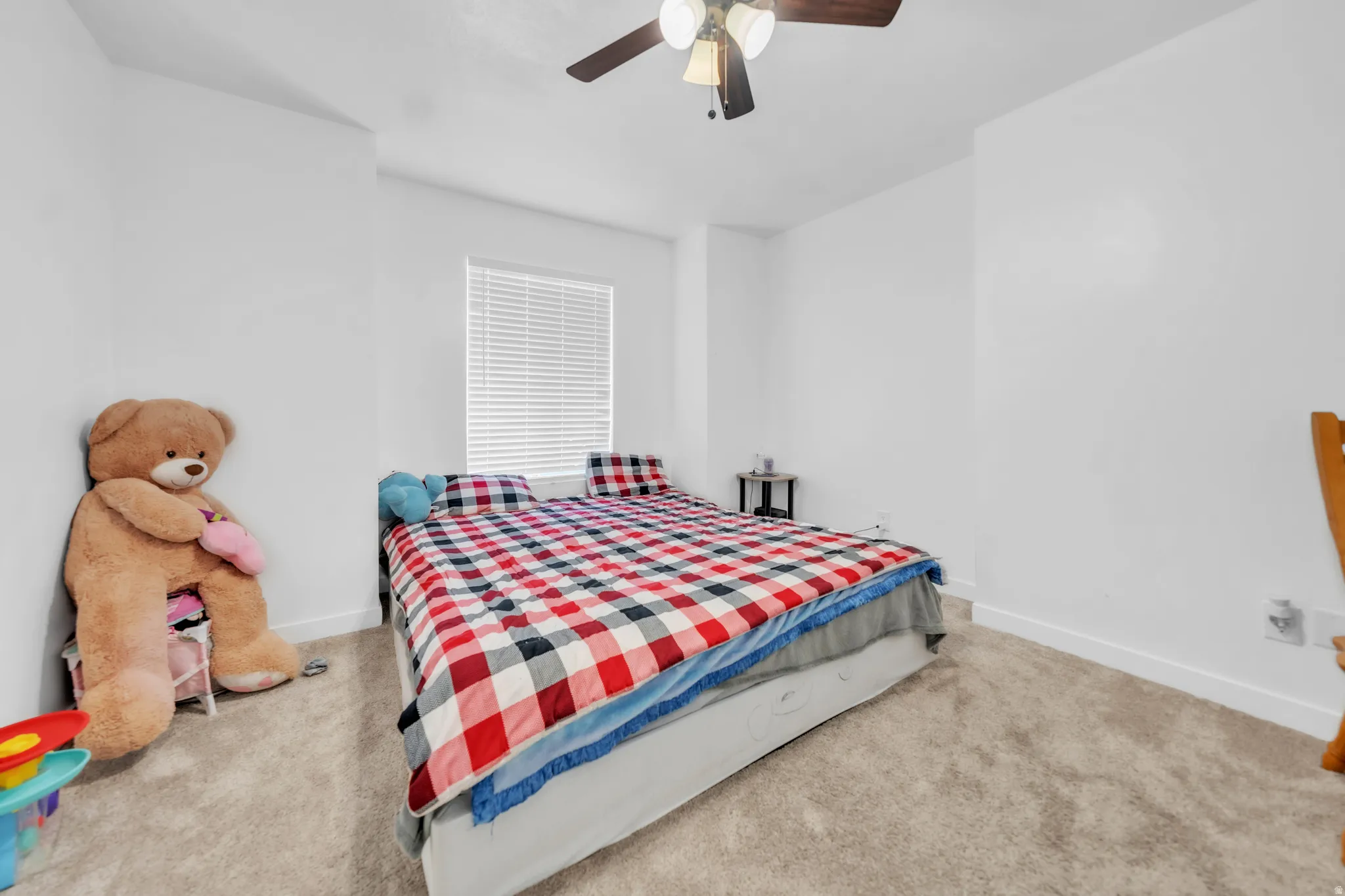 Carpeted flooring, window with blinds, ceiling fan with integrated lighting, and neutral wall finishes