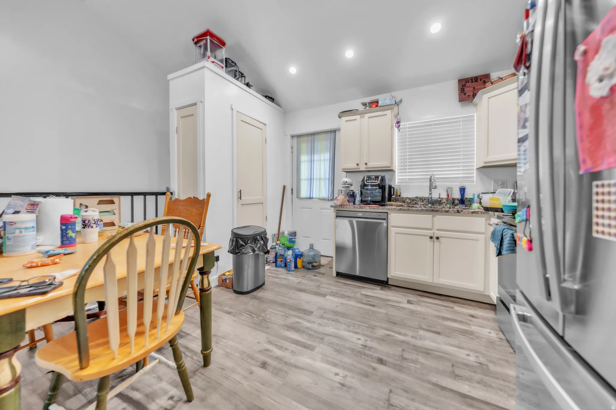 Kitchen featuring light wood-finish flooring, recessed lighting, and cream-colored cabinetry with granite-style countertops