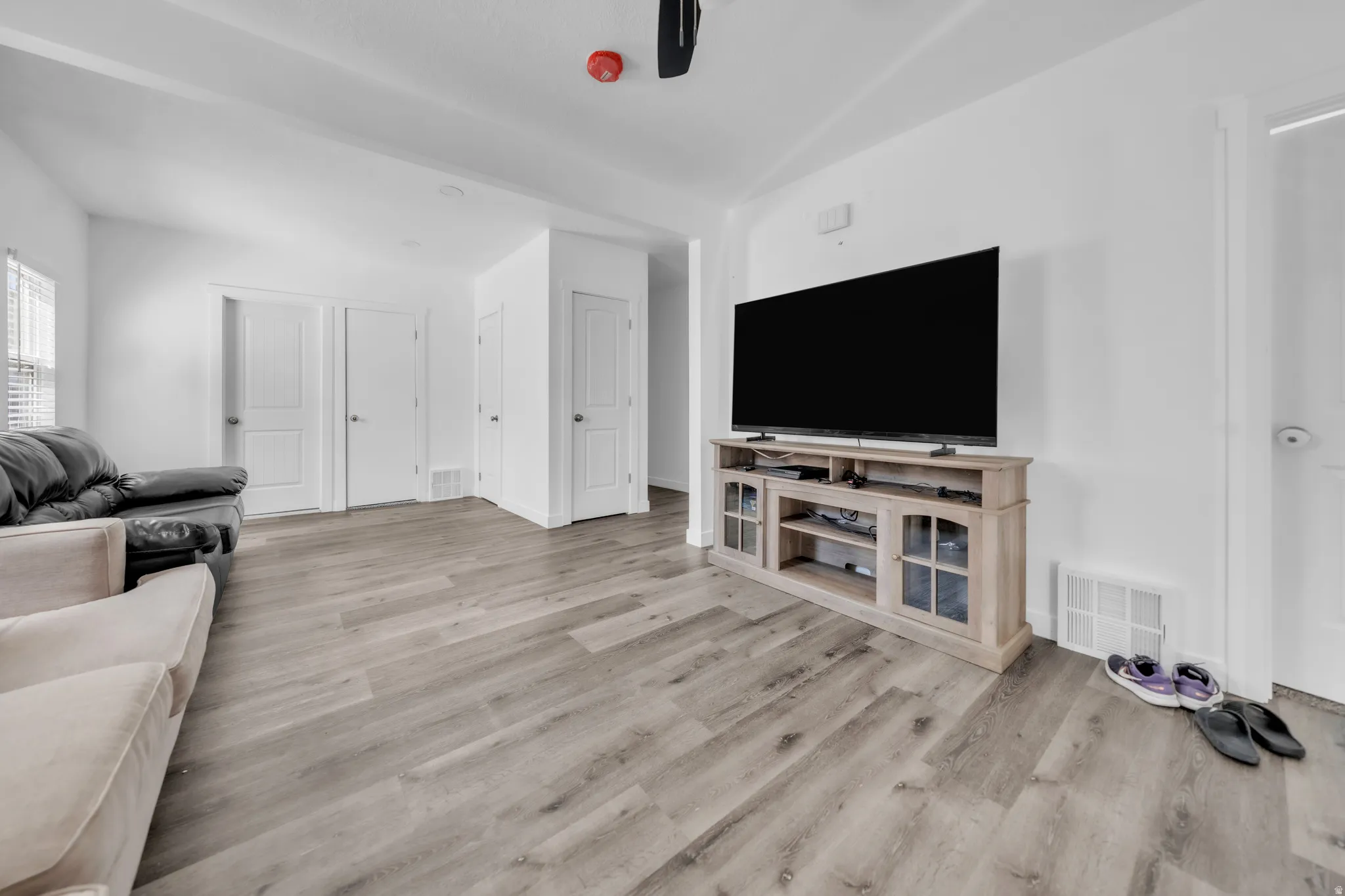 Wood-finish flooring throughout, white walls, and multiple white doors