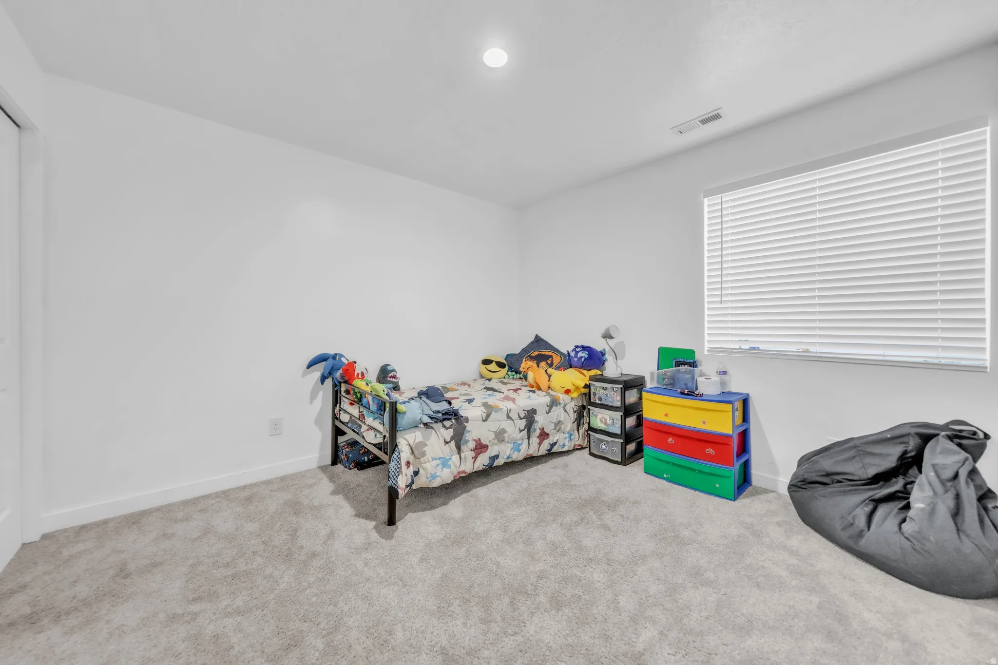 Recessed ceiling light, wall-to-wall carpeting, and a window with blinds