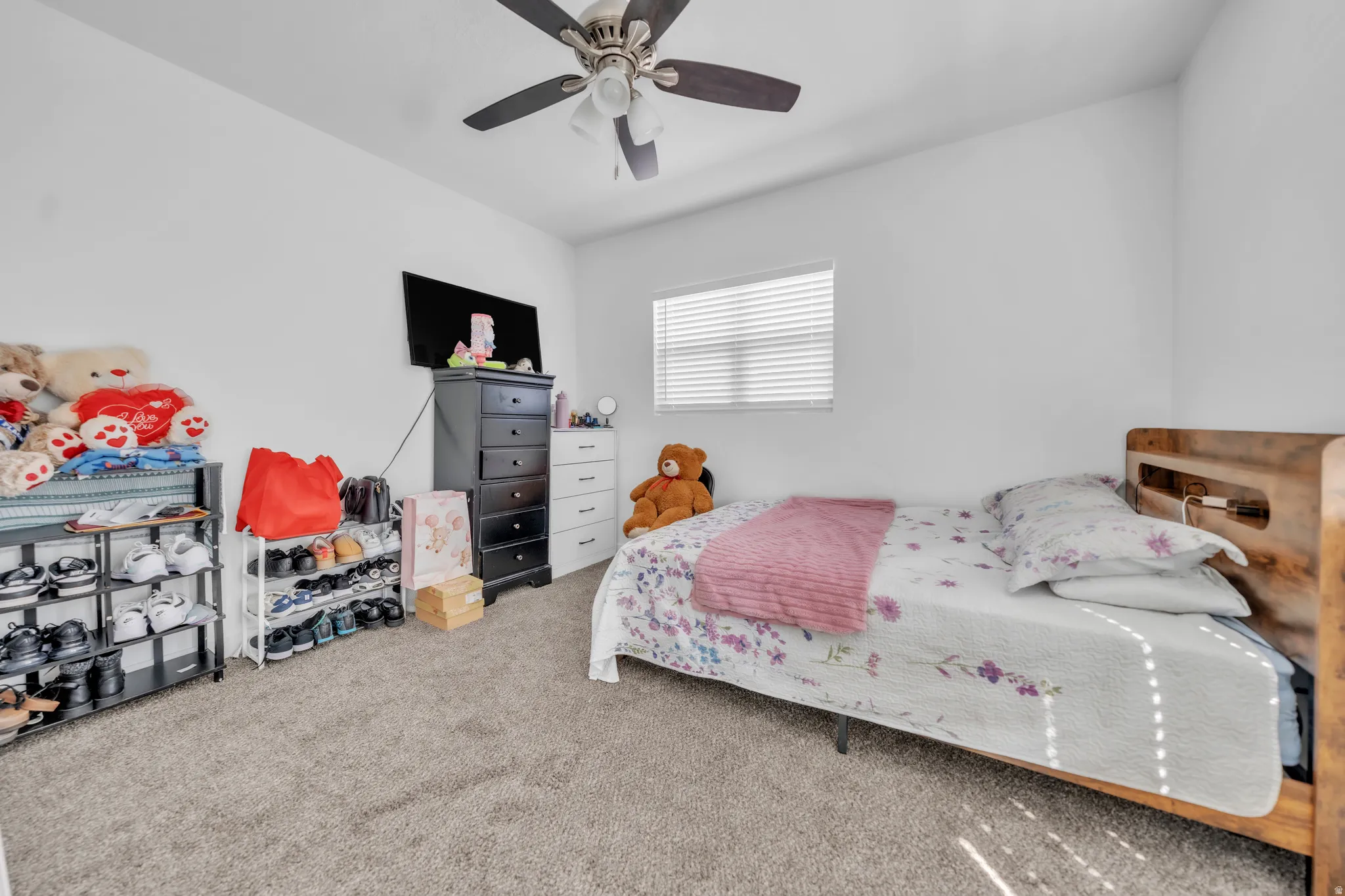 Carpeted room with a ceiling fan, a window featuring horizontal blinds, and light-colored walls