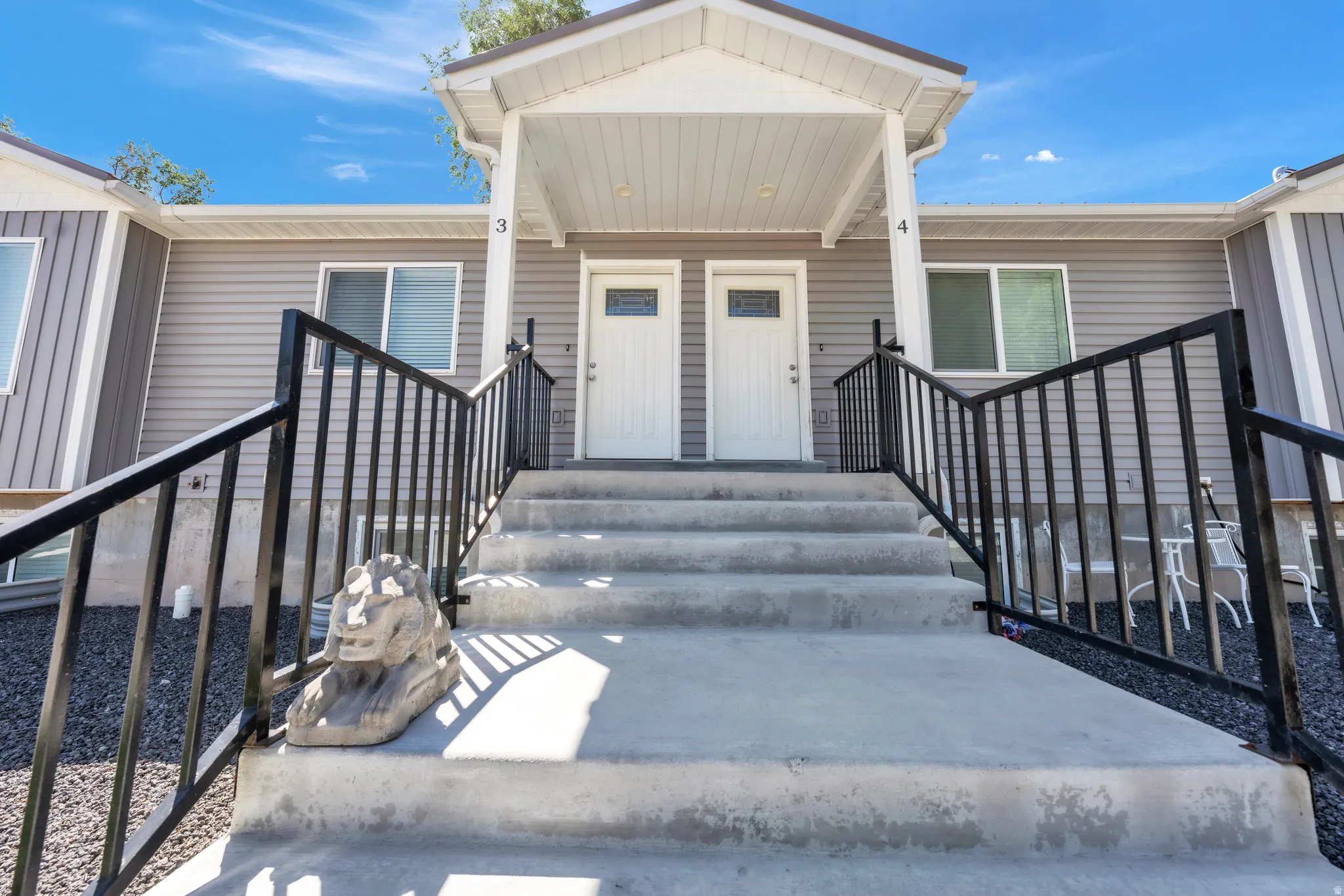 Multi-unit exterior with concrete steps and black metal railings