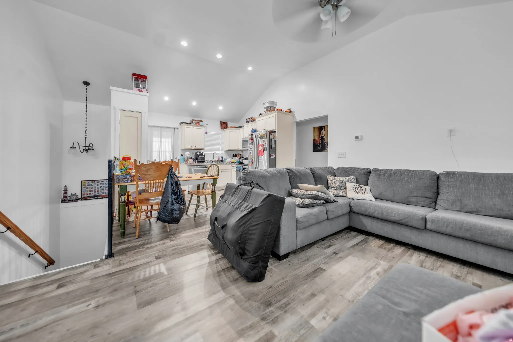 Wood-finish flooring, recessed lighting, vaulted ceiling, and a ceiling fan