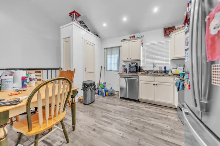 Kitchen featuring light wood-finish flooring, recessed lighting, and cream-colored cabinetry with granite-style countertops