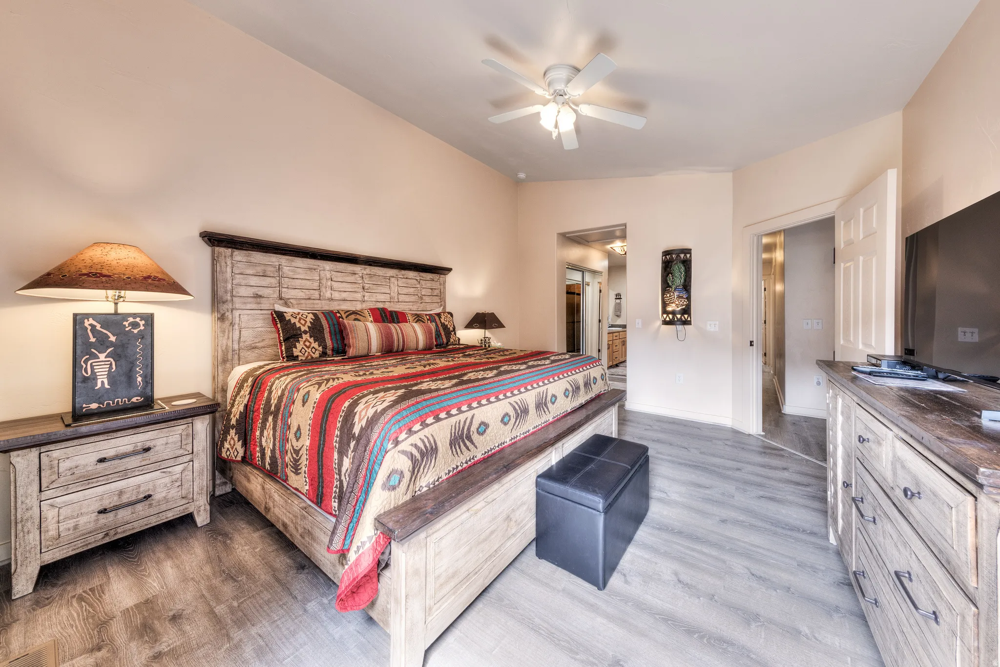 Wood-finish flooring, ceiling fan, and light wall tones