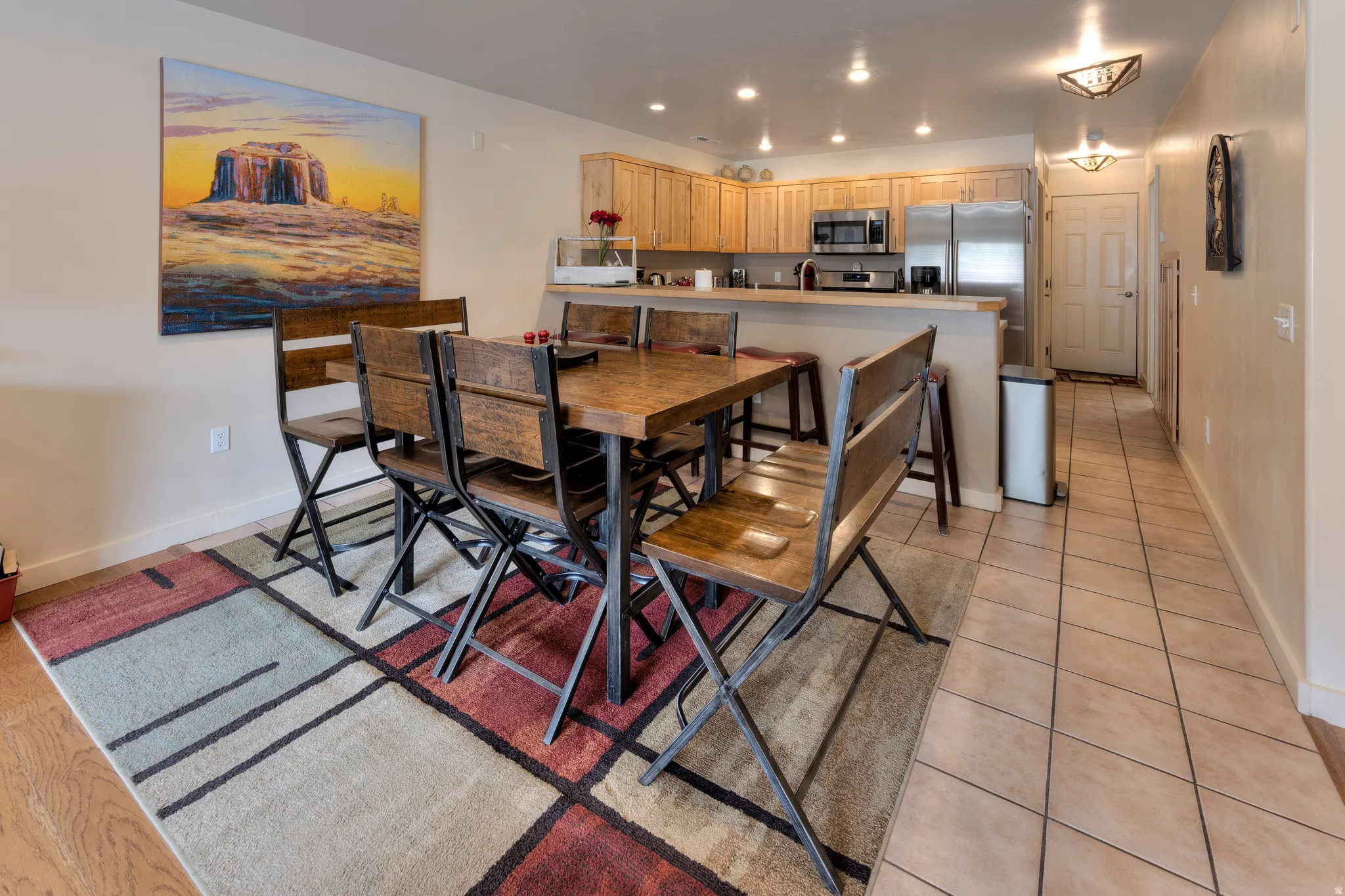 Kitchen with wood-finish cabinetry, stainless steel appliances, and recessed lighting