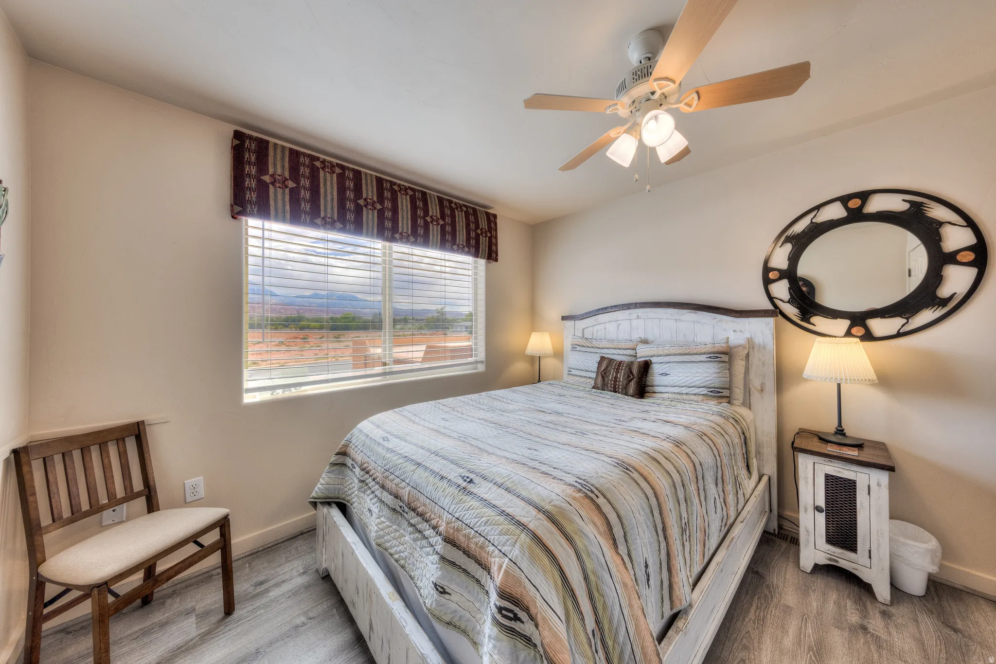 Wood-finish flooring, ceiling fan with integrated lighting, and a window with horizontal blinds