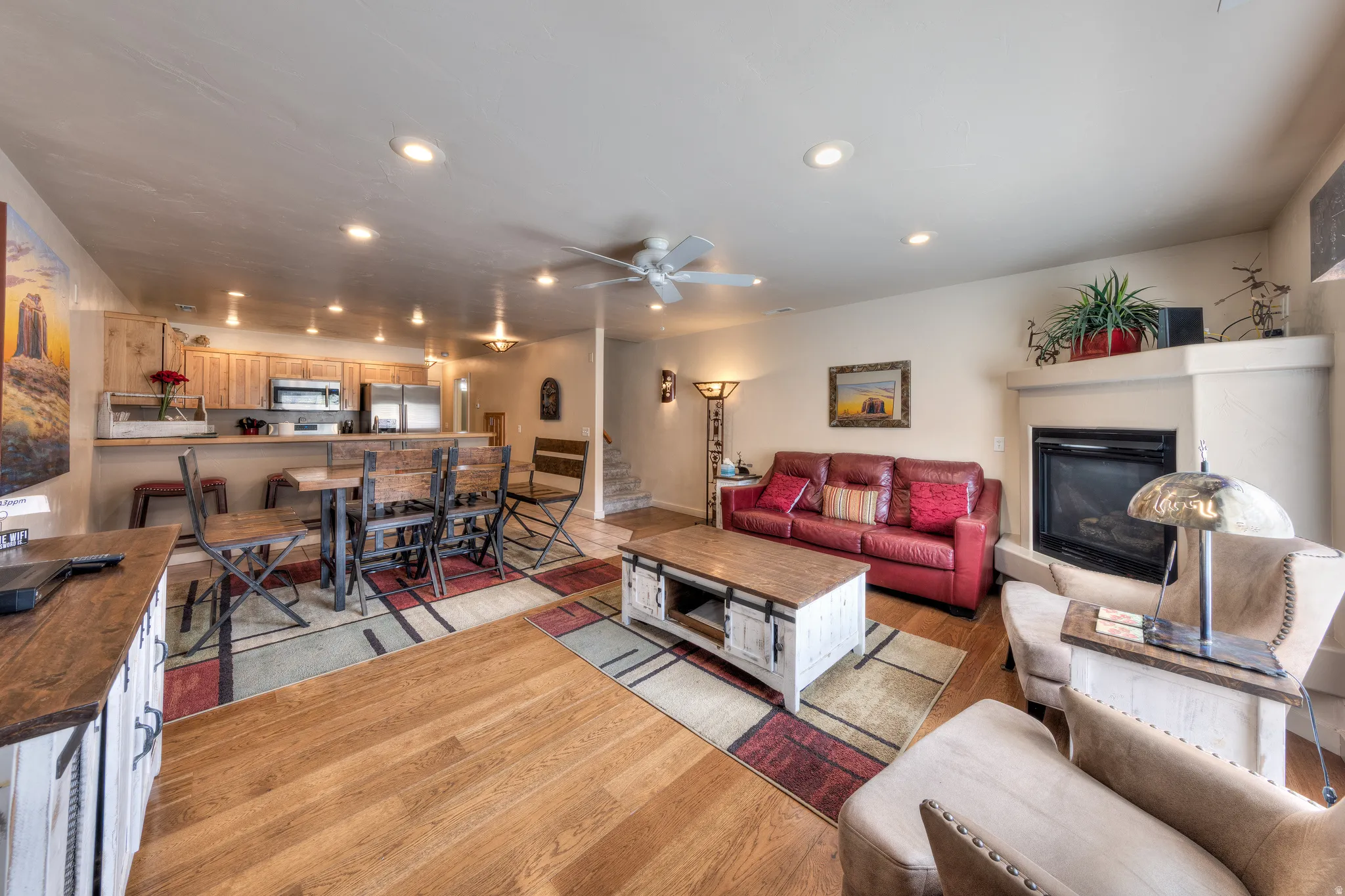Open-concept living space featuring wood-finish flooring, a built-in fireplace, and recessed lighting