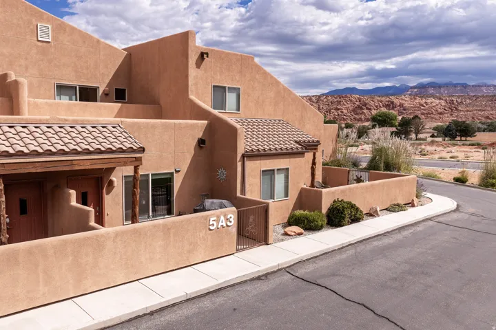 Southwestern-style stucco exterior with multiple windows and a tiled entry roof