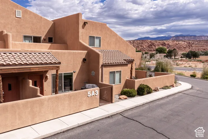 Southwestern-style stucco exterior with multiple windows and a tiled entry roof