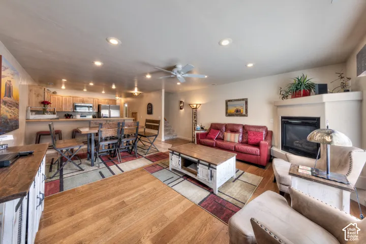 Open-concept living space featuring wood-finish flooring, a built-in fireplace, and recessed lighting