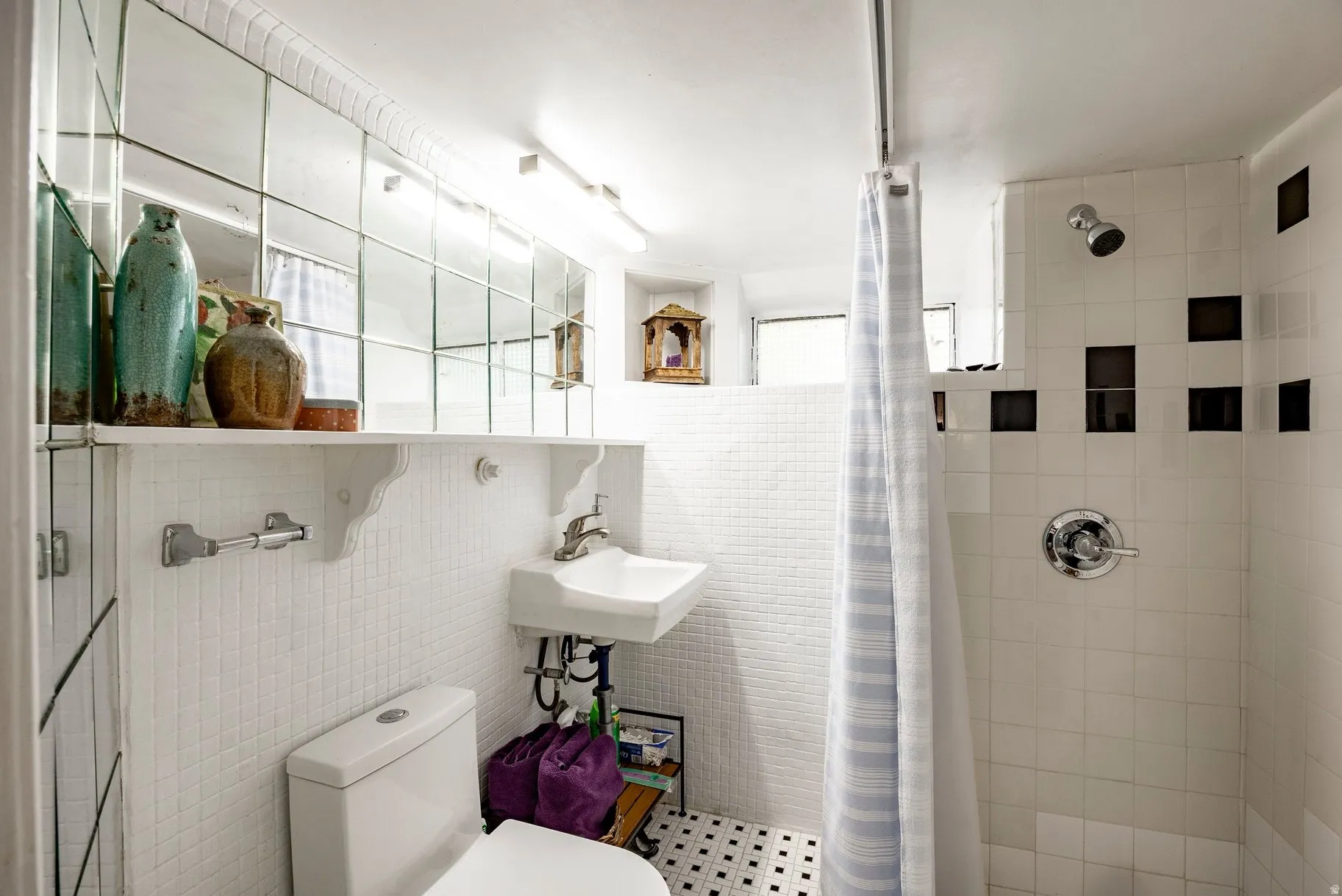White subway tile shower surround with black accent tiles