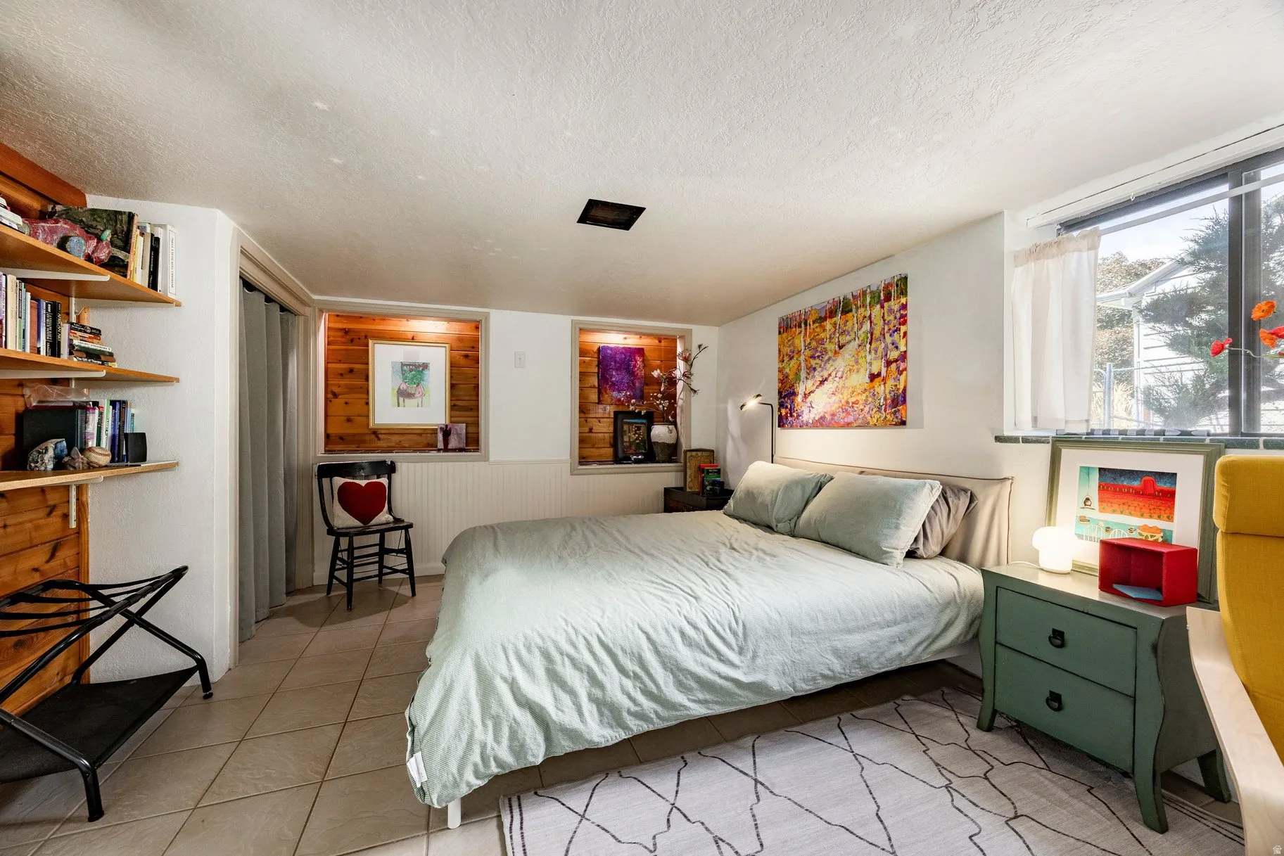 Neutral-toned tile flooring, wall-mounted wood shelving, wood paneling accents, and a window with natural light