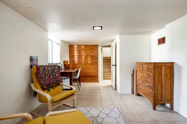 Tile flooring paired with white walls, wood panel accent wall, and recessed ceiling lighting