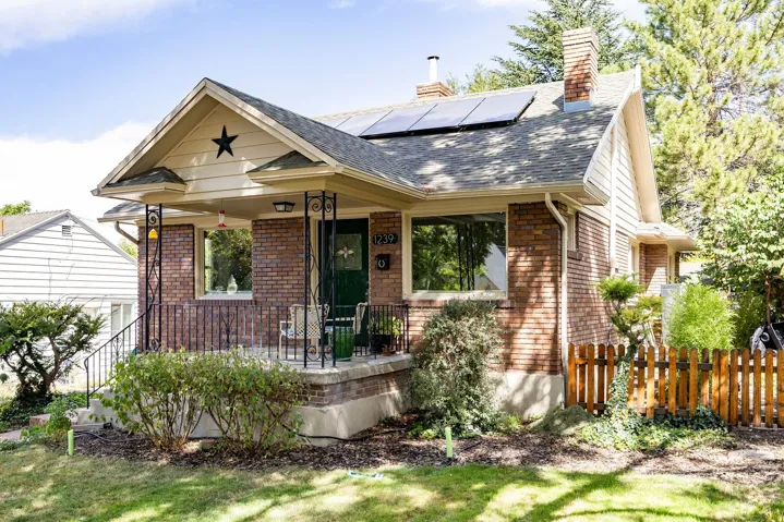 Brick exterior with a covered porch featuring decorative metal railings