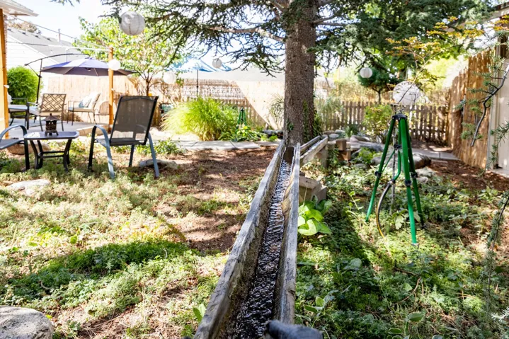 Patio area with furniture, tree, and wooden fence