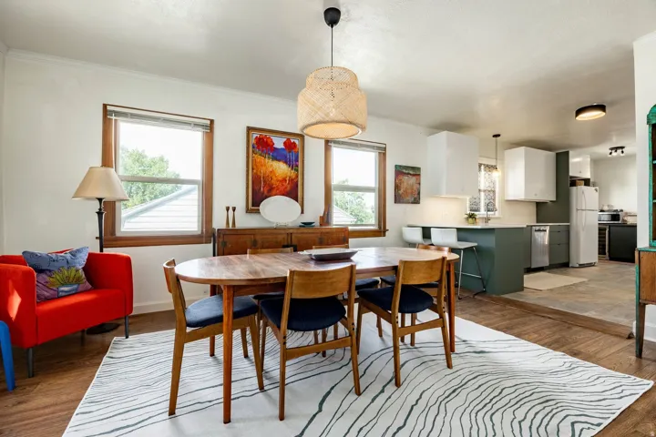 Dining area with wood-finish flooring, two windows with wood trim, and a built-in sideboard