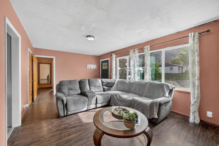 Wood-finish flooring, multiple large windows, flush mount ceiling fixture, solid core doors, and a front entry door with glass panels