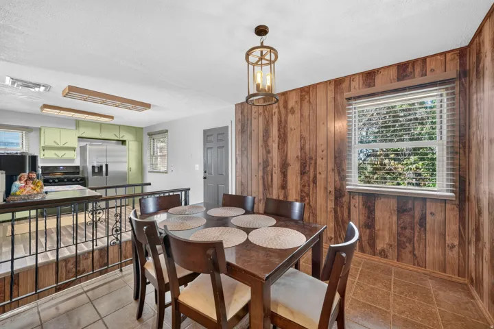 Wood-paneled wall, tiled flooring, and a decorative pendant light fixture