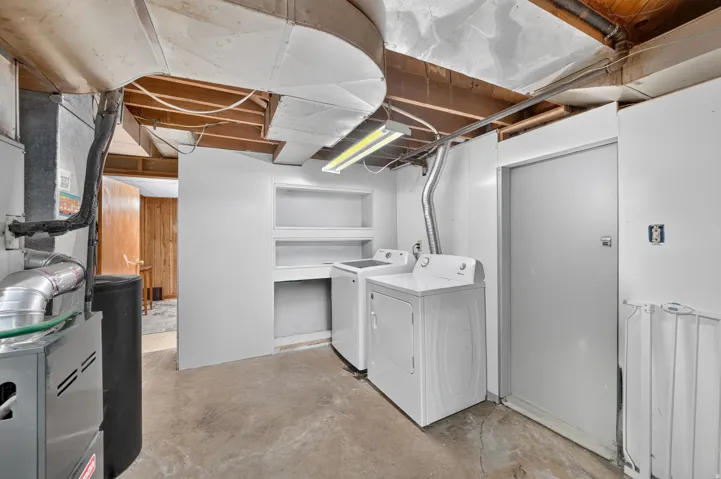Dedicated laundry area with built-in shelving, a washer, and a dryer