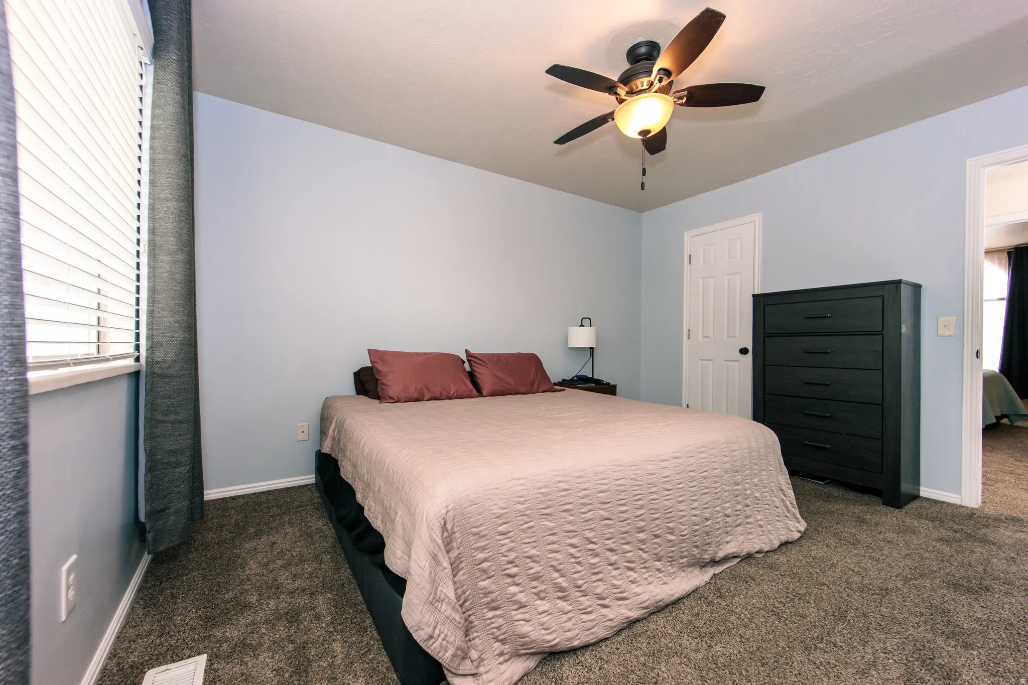 Wall-to-wall carpeting, ceiling fan with integrated lighting, and painted walls