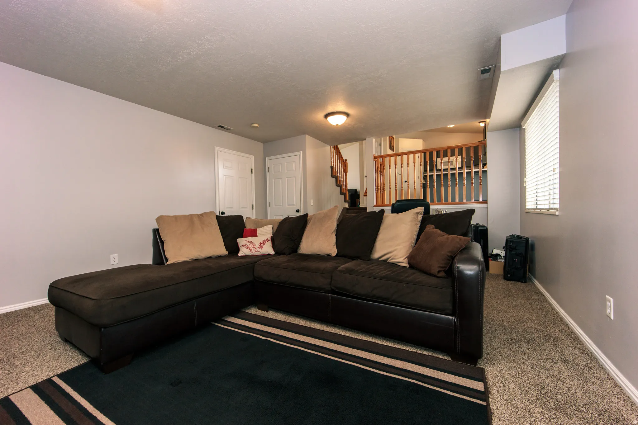 Carpeted flooring, neutral wall paint, white trim, window with blinds, and white interior doors