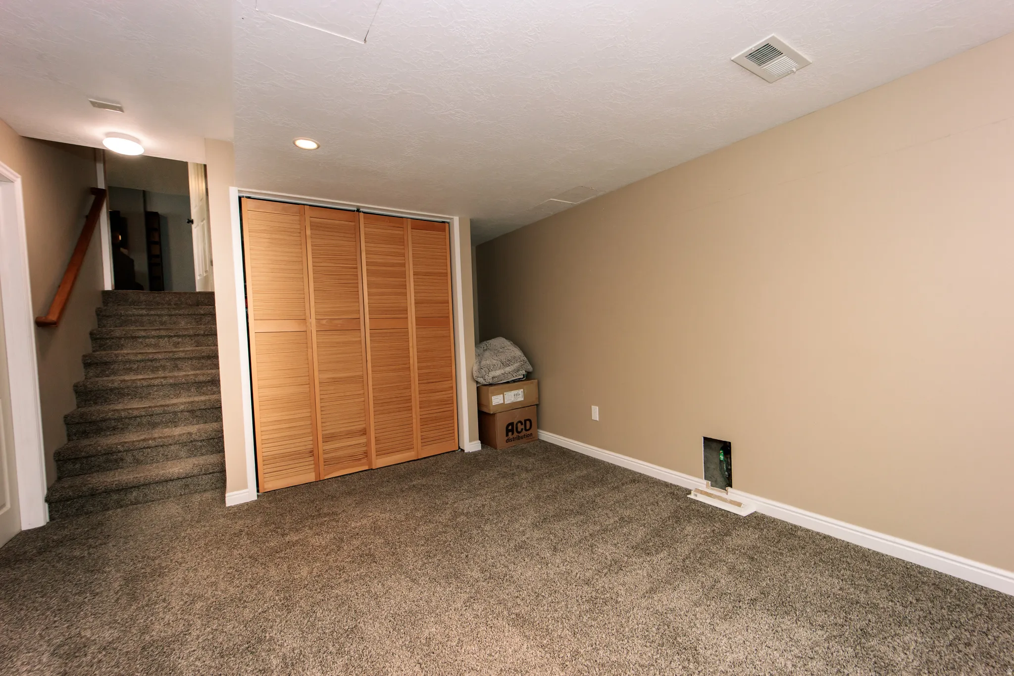 Carpeted flooring, wood-finish bi-fold closet doors, and recessed lighting