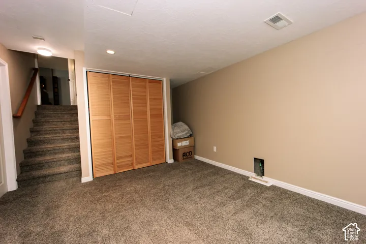 Carpeted flooring, wood-finish bi-fold closet doors, and recessed lighting