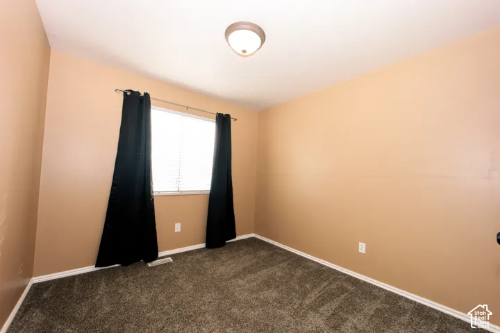 Neutral-toned walls complement the window with blinds, providing natural light to the carpeted floor