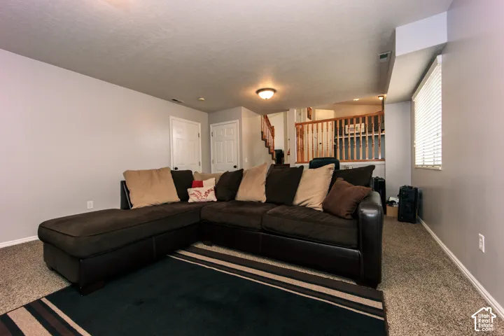 Carpeted flooring, neutral wall paint, white trim, window with blinds, and white interior doors